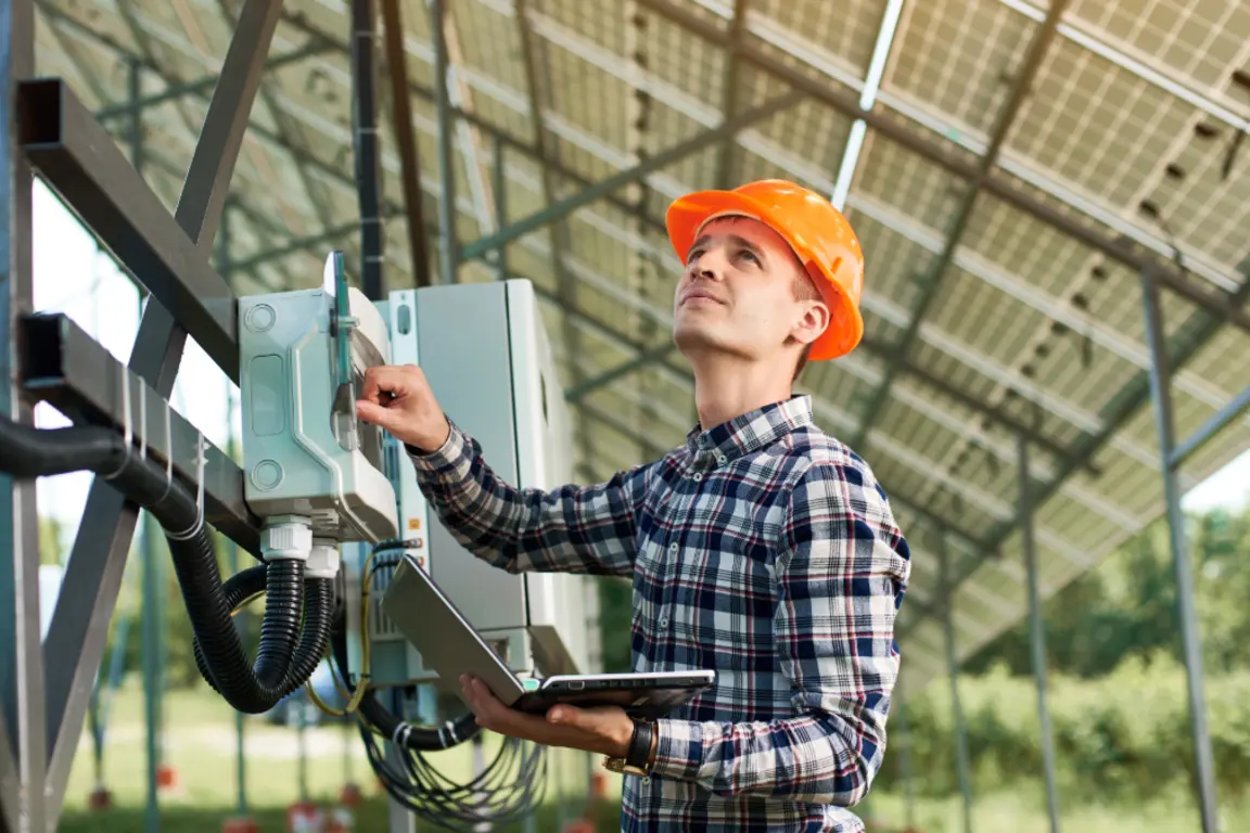 Man in hard hat looking at solar panels